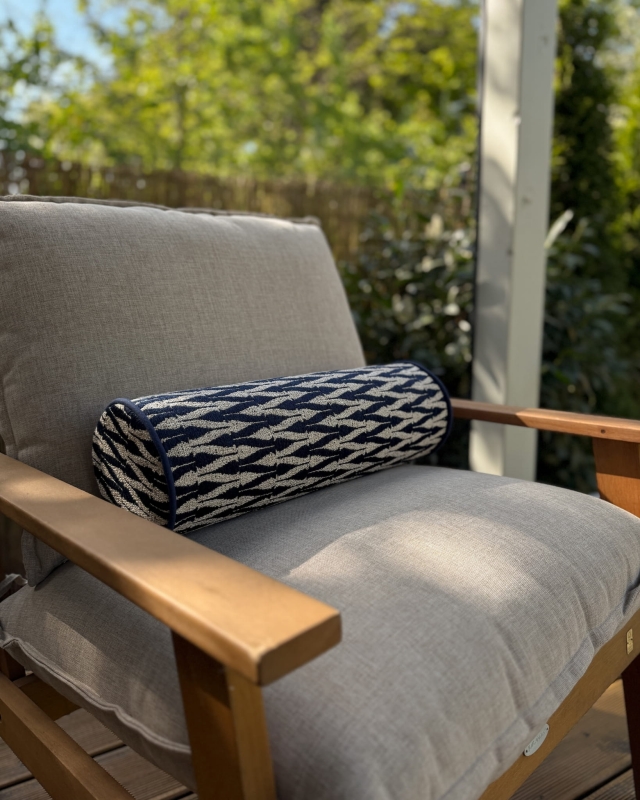 Granatowa poduszka wałek w geometryczny wzór VERSO II - aranżacja na fotelu na tarasie