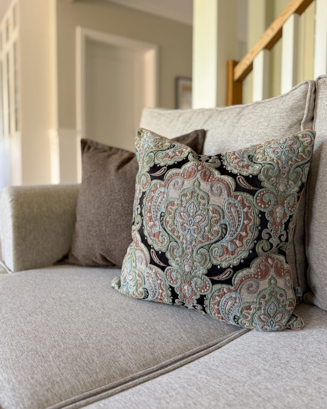 Poduszka z wielokolorowym, ornamentowym wzorem na czarnym tle ZORI - aranżacja