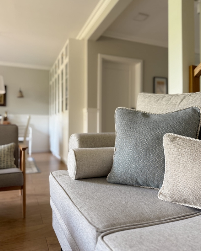 Błękitna poszewka na poduszkę ze sznurem GISELLE II 45x45 cm w aranżacji poduszek na kanapie.