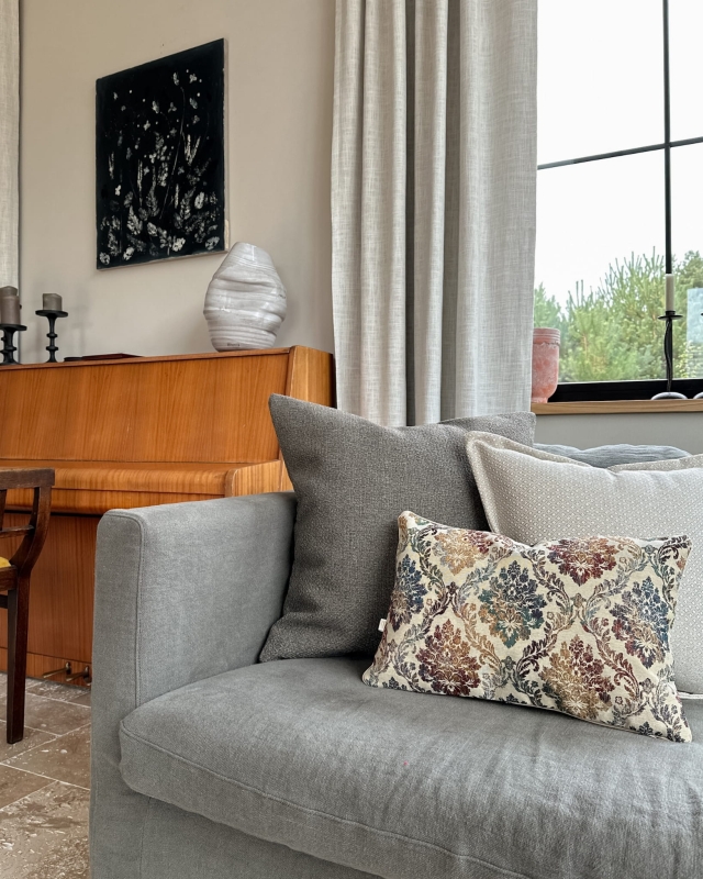 Duża brązowa poduszka pleciona LAS 60x60 cm w aranżacji poduszek na kanapie.