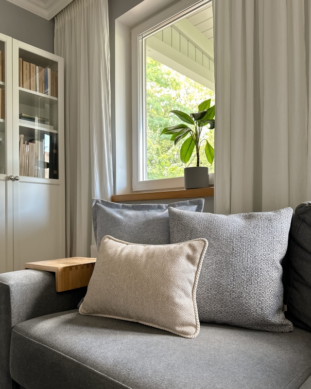 Błękitno-beżowy zestaw poduszek na kanapie.