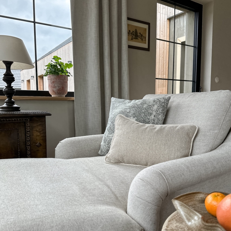 Szaro-beżowy zestaw poduszek na szezlongu.