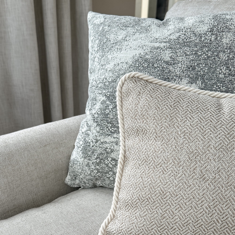 Szaro-beżowy zestaw poduszek na szezlongu - zbliżenie.