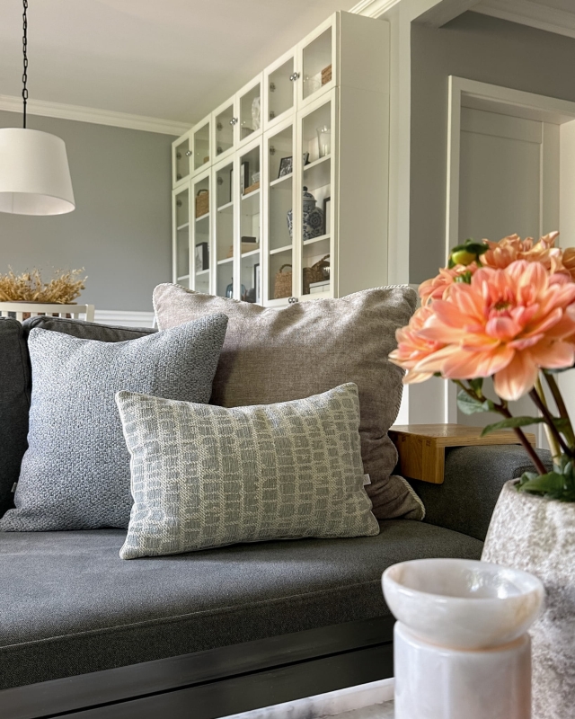 Błękitno-beżowy zestaw poduszek w aranżacji na kanapie.