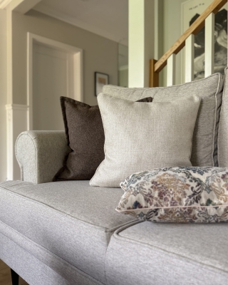 Jasnobeżowa poduszka z plecionki 45x45 cm SPLOT w aranżacji poduszek na kanapę.