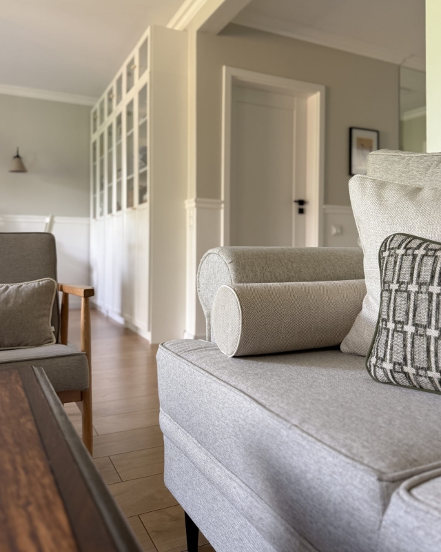 Lniana poduszka wałek w jodełkę LINEA w aranżacji na kanapie.