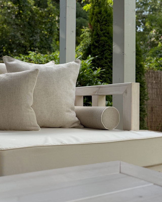 Lniana poduszka wałek w jodełkę LINEA w aranżacji na kanapie na tarasie.
