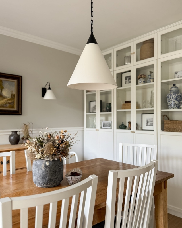 Czarna lampa wisząca z łańcuchem z białym stożkowym abażurem w odcieniu złamanej bieli TIARA BLACK jako lampa wisząca nad stół w salonie.