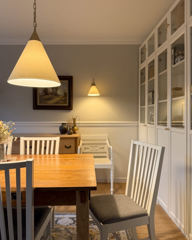 Złota lampa wisząca na łańcuchu z białym abażurem w odcieniu złamanej bieli TIARA GOLD biały w aranżacji jako lampa nad stół w jadalni.