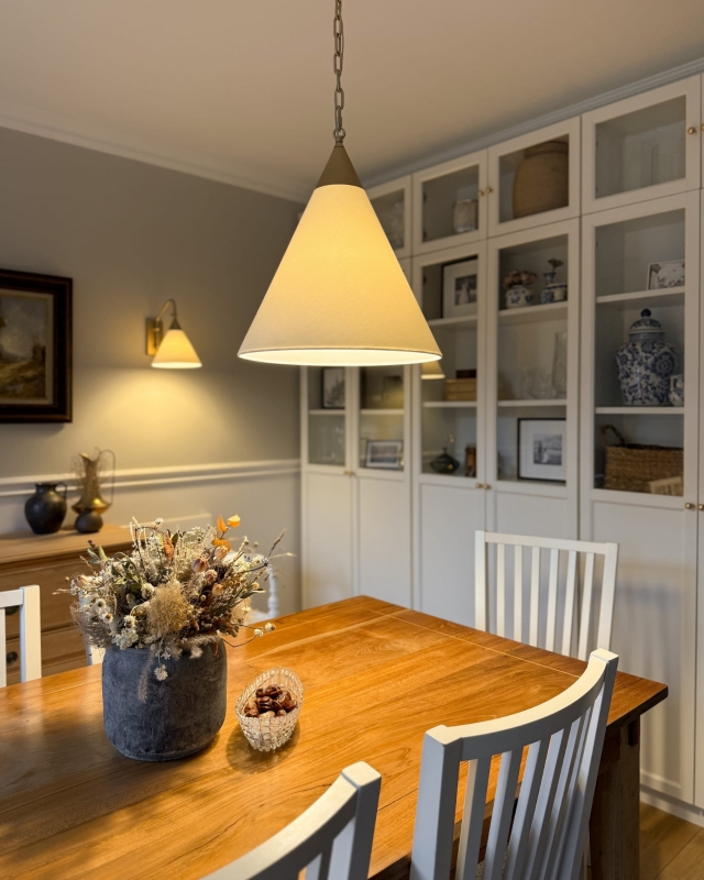 Złota lampa wisząca na łańcuchu z białym abażurem w odcieniu złamanej bieli TIARA GOLD biały w aranżacji jako lampa nad stół w jadalni.