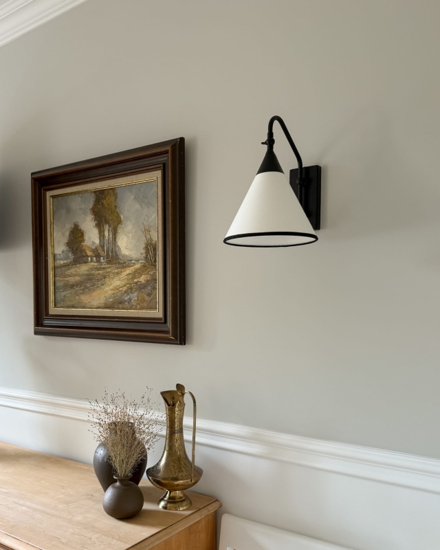 Regulowany czarny kinkiet z biało-czarnym abażurem TIARA BLACK w aranżacji w salonie.