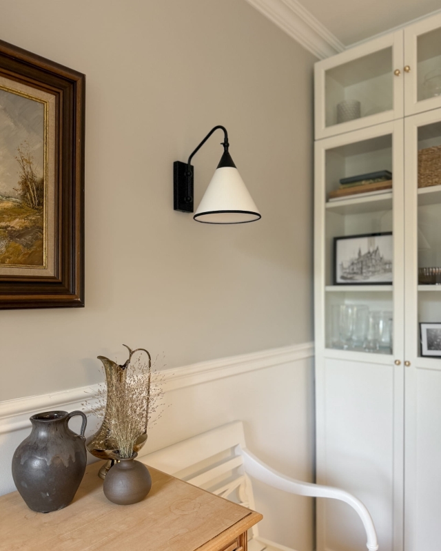 Regulowany czarny kinkiet z biało-czarnym abażurem TIARA BLACK w aranżacji w salonie.