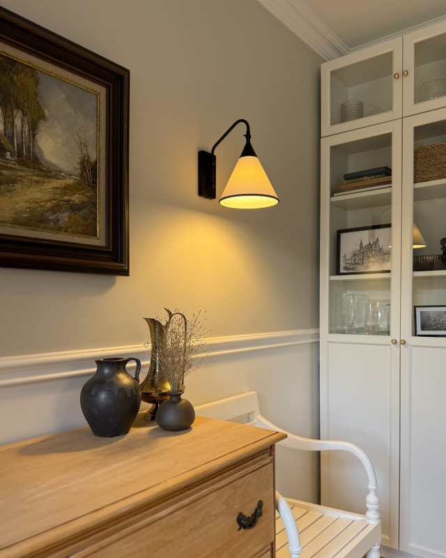 Regulowany czarny kinkiet z biało-czarnym abażurem TIARA BLACK w aranżacji w salonie.