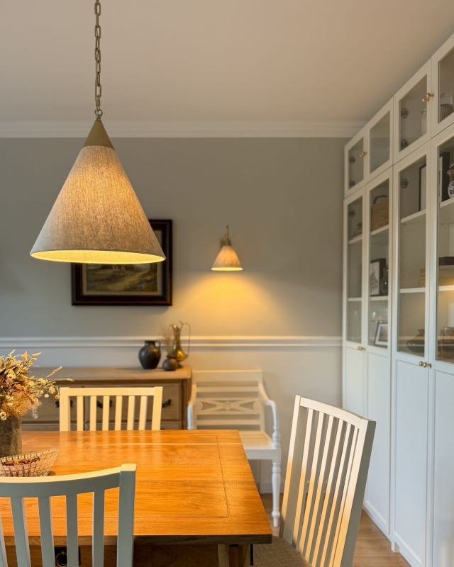 Stożkowa złota lampa wisząca na łańcuchu z lnianym abażurem TIARA GOLD w aranżacji w salonie.