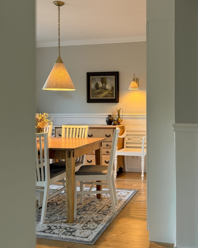 Stożkowa złota lampa wisząca na łańcuchu z lnianym abażurem TIARA GOLD w aranżacji w salonie.