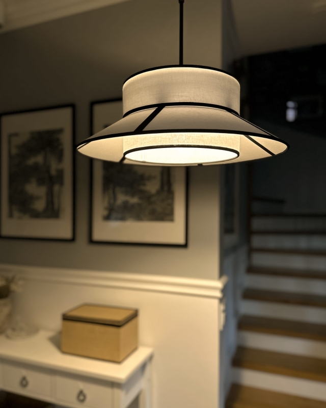 Aranżacja biało-czarnych lamp wiszących na łańcuchu w salonie.