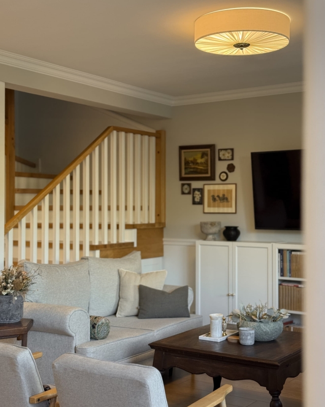 Duża elegancka lampa sufitowa w kolorze złamanej bieli w salonie PLISE BLACK III - zapalone światło.