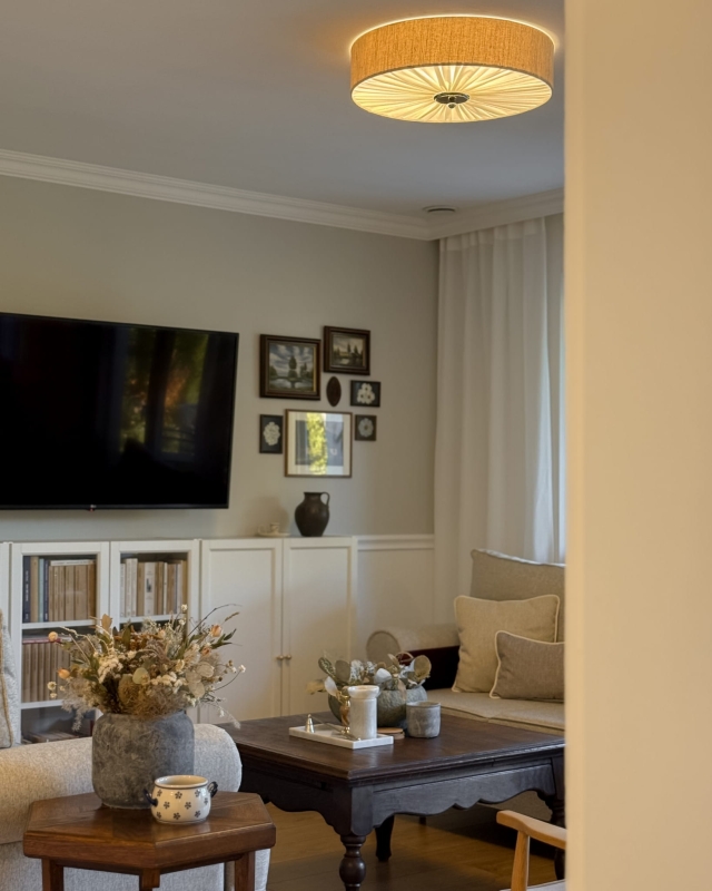 Elegancka lniana lampa sufitowa z niklowanym dekorem w salonie PLISE SILVER III - zapalone światło.