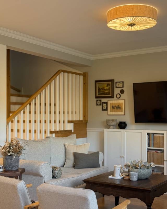 Elegancka lniana lampa sufitowa z niklowanym dekorem w salonie PLISE SILVER III - zapalone światło.