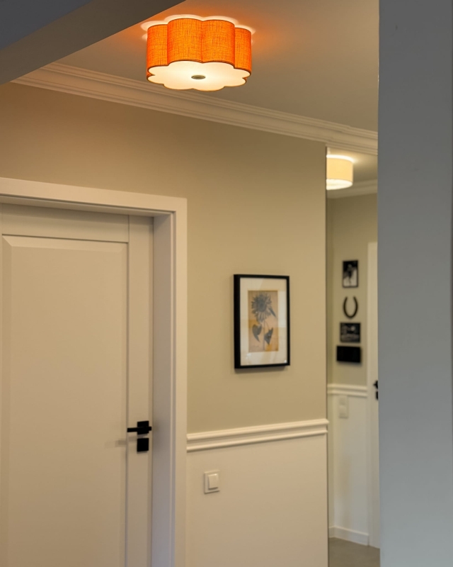 Pomarańczowa lampa sufitowa w kształcie kwiatu jako oświetlenie korytarza AUREA GOLD - zapalone światło.