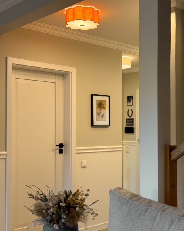 Pomarańczowa lampa sufitowa w kształcie kwiatu jako oświetlenie korytarza AUREA GOLD - zapalone światło.