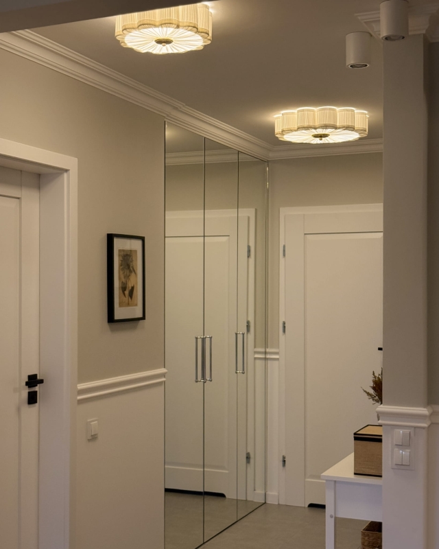 Biały plafon w kształcie kwiatu z mosiężnym dekorem PEONIA I śmietankowa biel w aranżacji w korytarzu razem z większą lampą z tej samej kolekcji - zapalone światło.