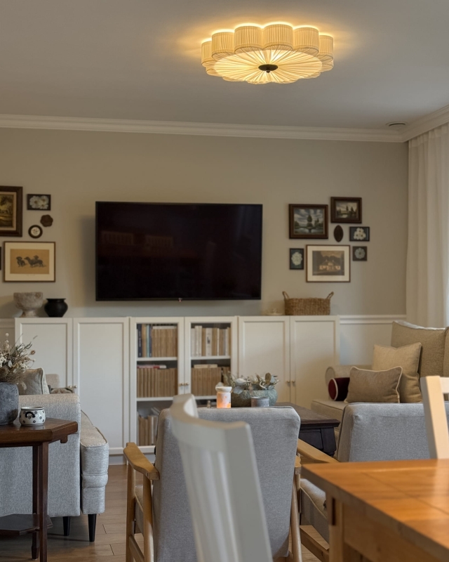 Duży biały plafon w kształcie kwiatu z czarnym dekorem PEONIA BLACK III śmietankowa biel w aranżacji jako główna lampa sufitowa do salonu - zapalone światło.