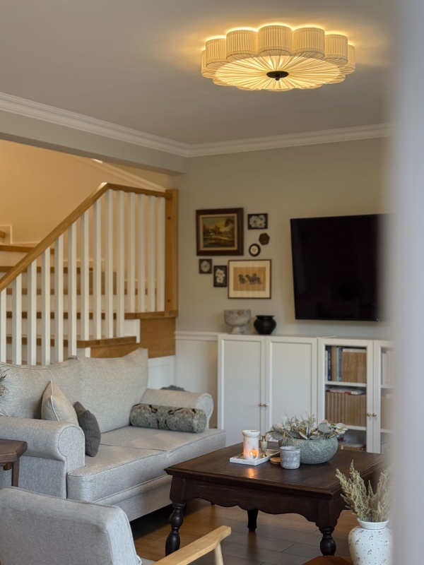 Duży biały plafon w kształcie kwiatu z czarnym dekorem PEONIA BLACK III śmietankowa biel w aranżacji jako główna lampa sufitowa do salonu - zapalone światło.