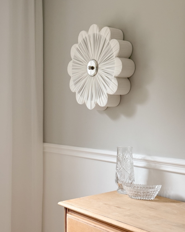 Biały kinkiet ze srebrnym niklowanym dekorem PEONIA SILVER II śmietanka w aranżacji na ścianie.