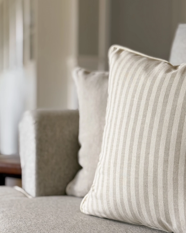 Kwadratowa poszewka w beżowo-kremowe paski SAND 45x45 cm - aranżacja na kanapie w salonie.