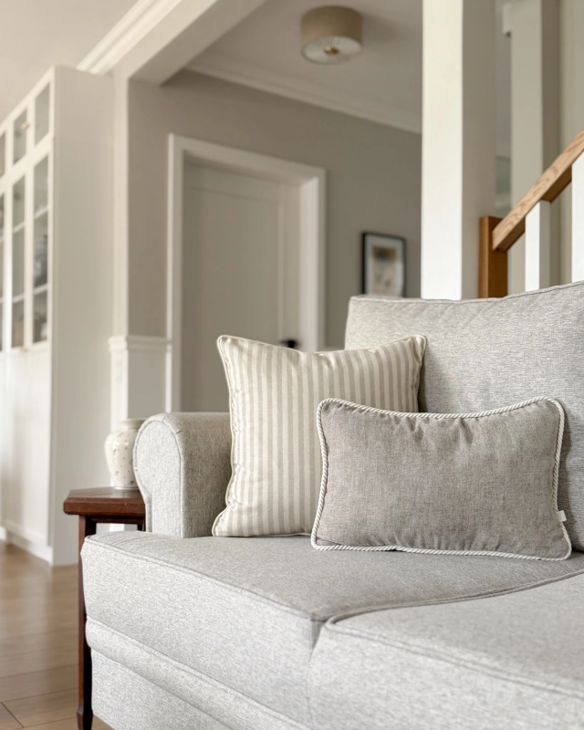 Kwadratowa poszewka w beżowo-kremowe paski SAND 45x45 cm - aranżacja na kanapie w salonie.