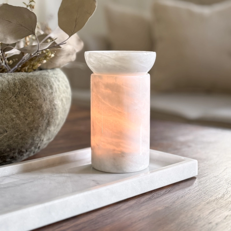 Biały kominek zapachowy z marmuru na wosk zapachowy MARBEA przepuszczający światło świeczki.