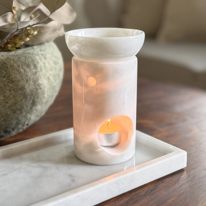 Biały kominek zapachowy z marmuru na wosk zapachowy MARBEA przepuszczający światło świeczki.