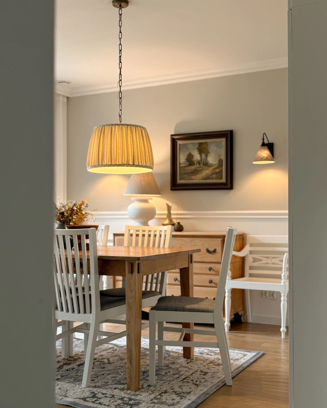 Mosiężna patynowana lampa wisząca na łańcuchu z marszczonym beżowym abażurem w paski SILIA PATINA I paski w aranżacji jako lampa wisząca nad stół w jadalni w klasycznym stylu.