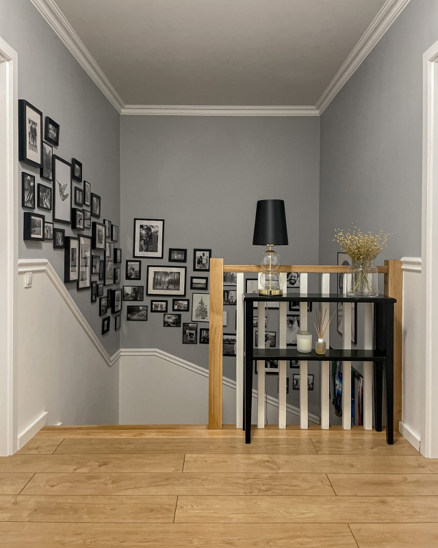 Złota lampka stołowa ze szklanymi elementami i czarnym abażurem Kaspa COCO w aranżacji na czarnej konsoli.