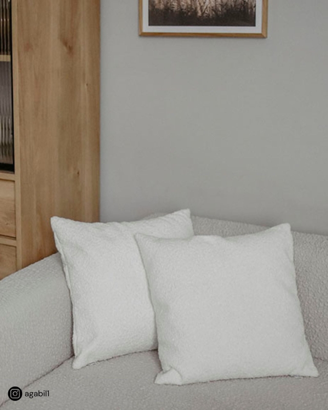 Białe poduszki boucle na kanapę.